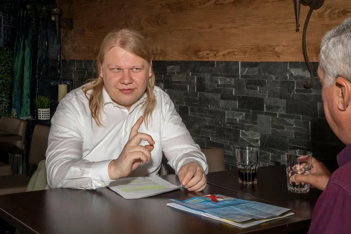 Zwei Männer sitzen an einem Tisch und diskutieren.